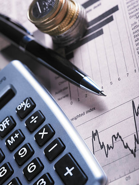 gráfico con monedas financieros y calculadora - home finances recession newspaper finance fotografías e imágenes de stock