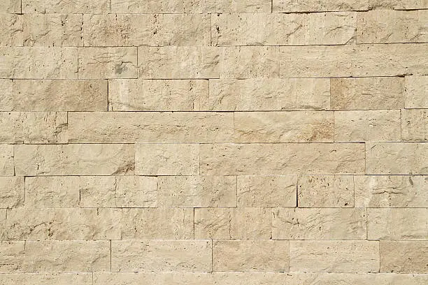 "Horizontal view of a layered, sandstone exterior wall building facade"