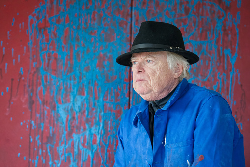 Painter wearing a smock shirt and black hat