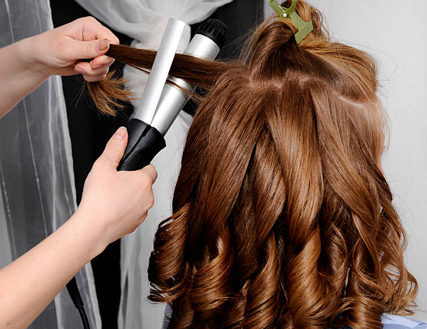 woman at hairdresser woman at hairdresser making her hair curly. curling tongs photos stock pictures, royalty-free photos & images