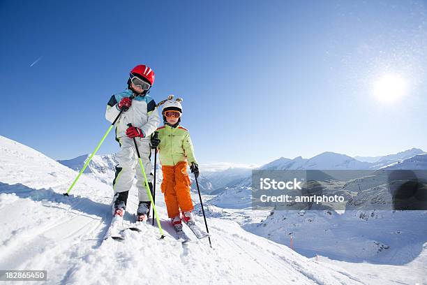 Foto de Crianças Em Traje De Esqui Em Declive e mais fotos de stock de Alpes europeus - Alpes europeus, Artigo de vestuário para cabeça, Branco