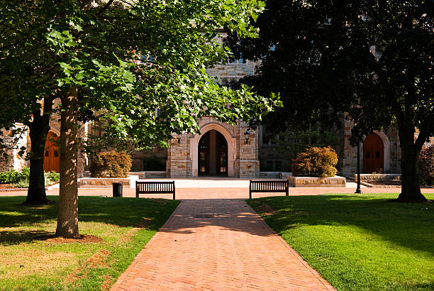 Brick walkway leading to educational building at Boston College "A brick walkway surrounded by green grass leading up towards an educational building at Boston College in Chestnut Hill, MA.Other images of Boston College:" boston college campus stock pictures, royalty-free photos & images