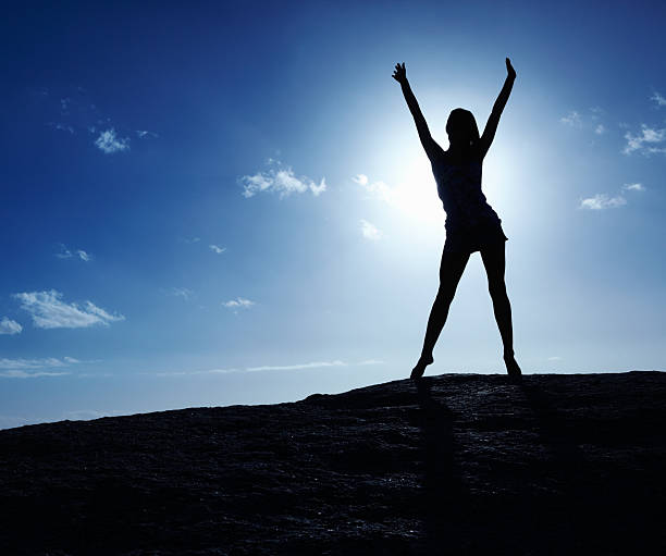 istock Silhouetted woman enjoying freedom at sunrise 182865785