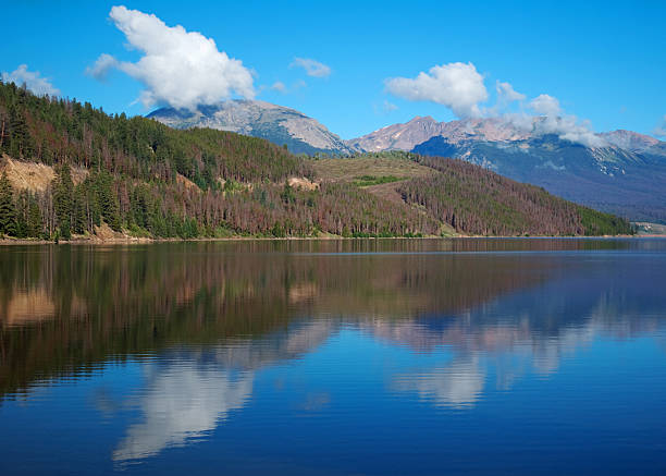 Lake Dillon reflecting mountains "Lake Dillon, Colorado, on a clear morning, reflecting a hillside and the Ten Mile Range in the background" tenmile range stock pictures, royalty-free photos & images