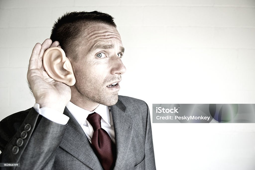 Biznesmen słuchania muzyki z dużym ucho białym tle - Zbiór zdjęć royalty-free (Garnitur)