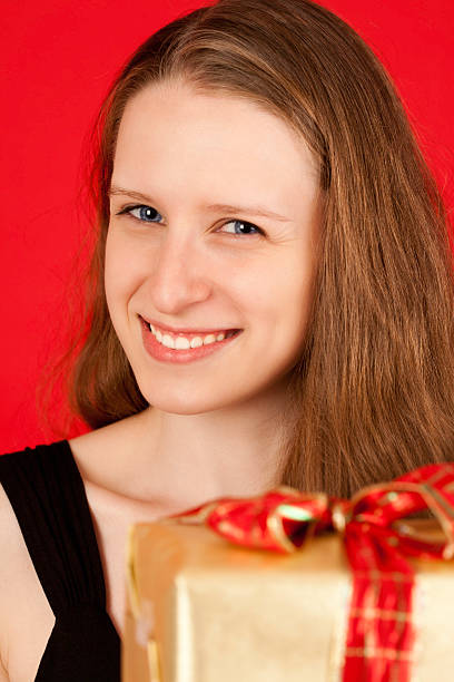 istock Cute Young Woman Holding a Wrapped Christmas Present 182866222