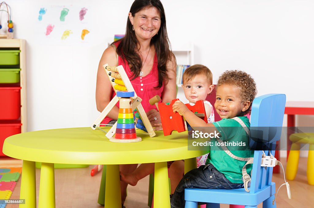 Feliz Biracial bebês/crianças desfrutando de brincar em um ambiente Berçário - Foto de stock de 12-17 meses royalty-free