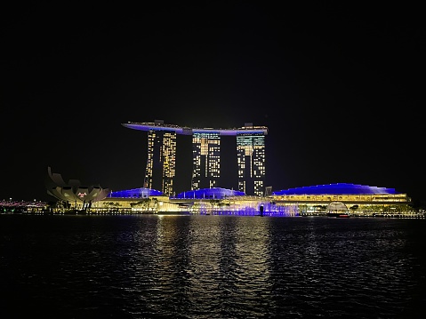 Marina Bay Sands transforms into a dazzling masterpiece at night, its iconic rooftop pool casting a shimmering reflection on the cityscape. The radiant lights of this architectural marvel create a breathtaking nocturnal spectacle, adding a touch of glamour to Singapore's skyline.