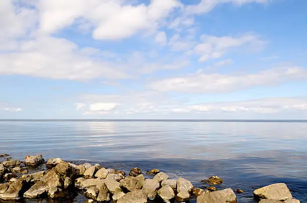 The IJsselmeer lake in the Netherlands. Calm lake under a blue sky with some clouds.