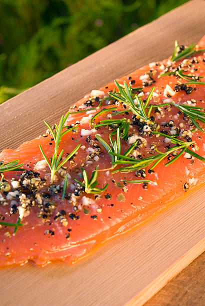 Salmon Fish Seafood Raw Fillet, Healthy Food Cooking & Barbeque Plank "Fresh wild salmon raw fish fillet steaks, marinated with rosemary, garlic, pepper and extra virgin olive oil on cedar plank, ready to grill. (SEE LIGHTBOXES BELOW for more seafood dinners, healthy eating, barbeque meals & outdoor summer cooking & food photos...)" sockeye salmon filet stock pictures, royalty-free photos & images