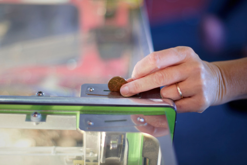 Caucasian woman putting coin in slot machine