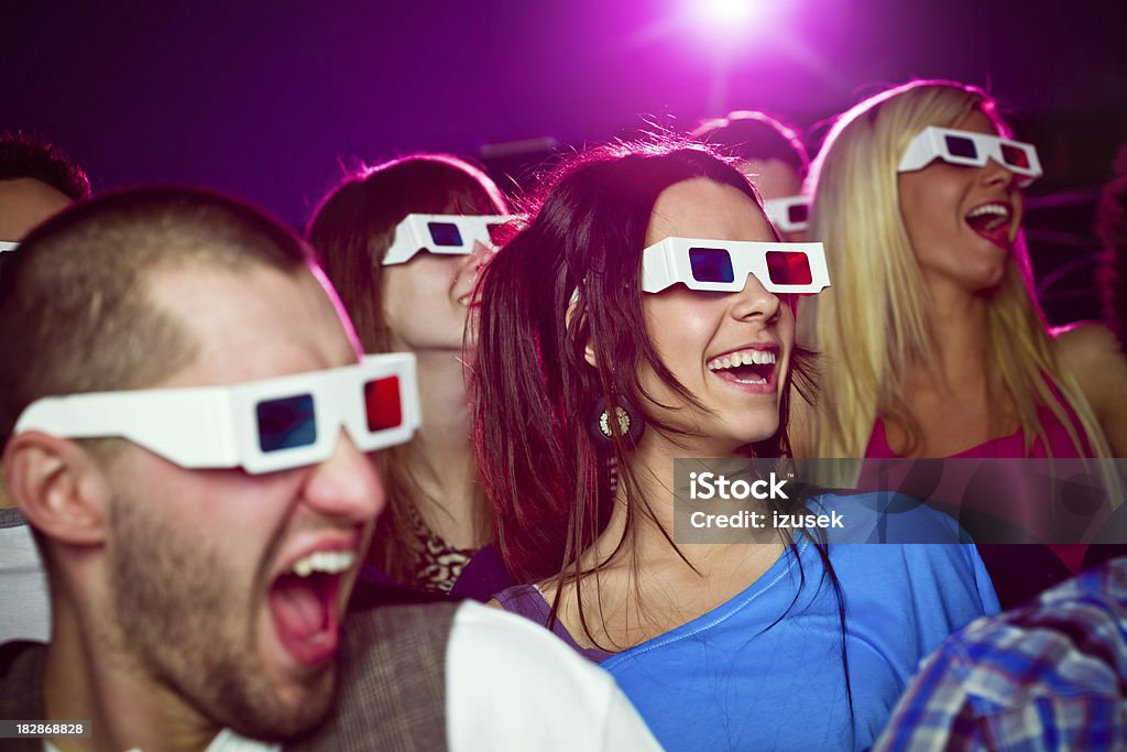 Young people in 3D move theater "Group of young adult people wearing 3D glasses, sitting in the cinema  and watching funny 3D move. Everyone laughing." 3-D Glasses Stock Photo