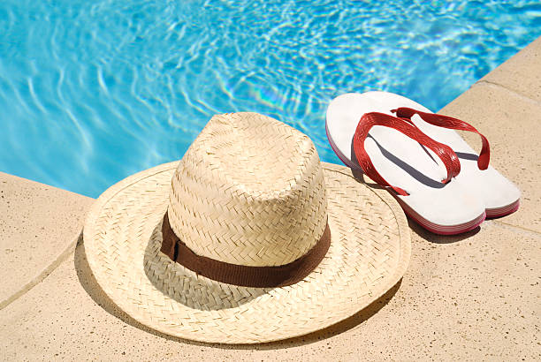 istock Sun Hat and Sandals by a Swimming Pool 182868912