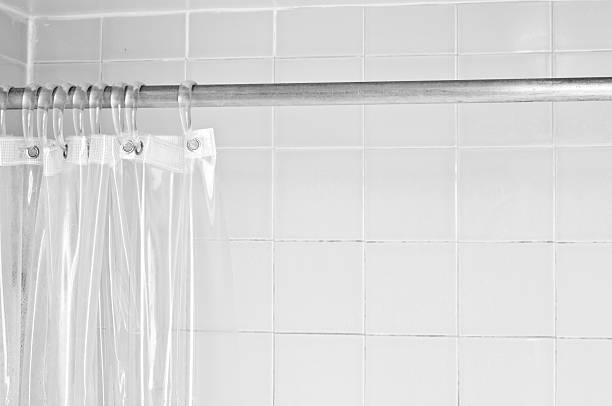 istock Clear shower curtain with a white tile shower 182869410