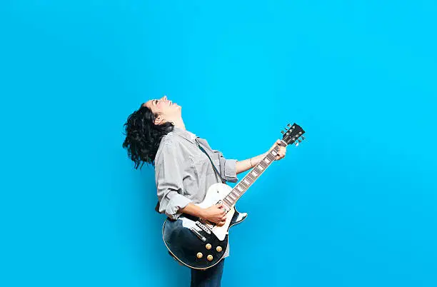 Guitar player against a blue background