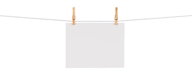Blank Card Hanging on a Clothesline against White This is a photo of a white card hanging on a clothesline isolated against a white background. Click on the links below to view lightboxes. clothespin wood stock pictures, royalty-free photos & images