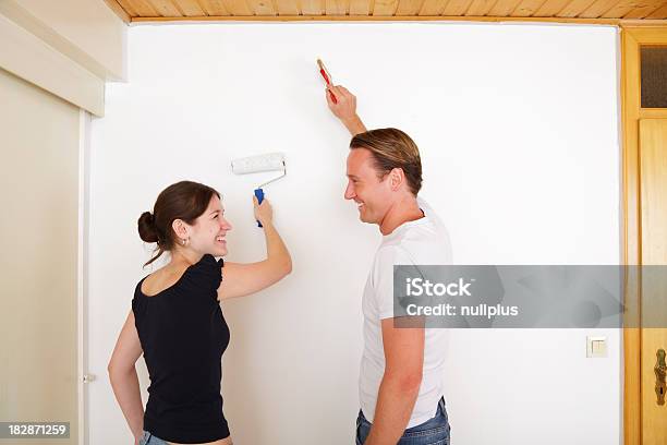 Casal Jovem Pintar As Paredes No Seu Novo Apartamento - Fotografias de stock e mais imagens de Adulto