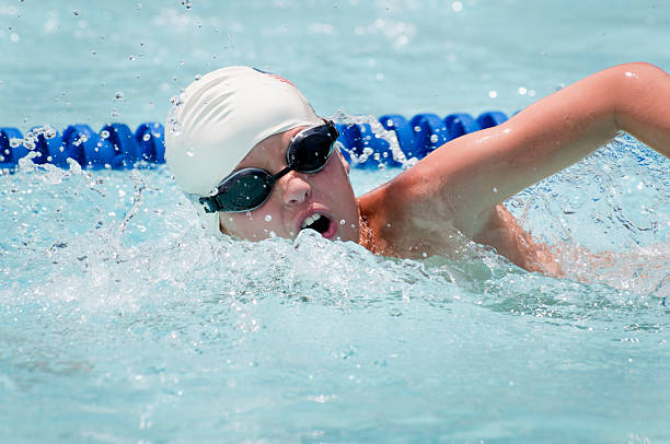 Close-up shot of a ten year-old boy swimming freestyle in an outdoor swim meet.More of this model: