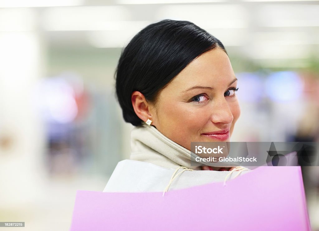 Close-up of a beautiful female holding shopping bags Close-up portrait of a smiling beautiful mid adult female holding shopping bags Shopping Mall Stock Photo