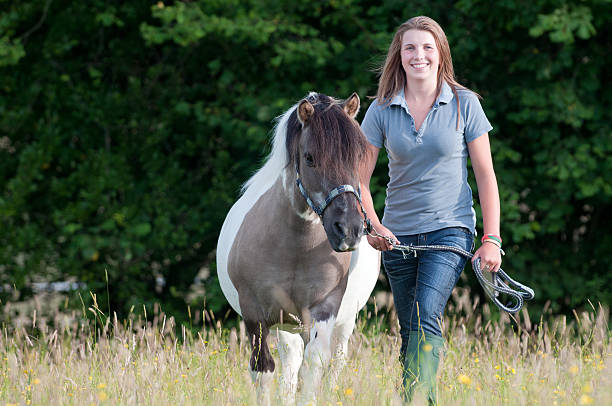 istock Young woman walking her pony 182872217