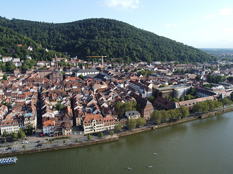 View of the Neckar riverbank and Heidelberg University in the old town with forest in the background, Heidelberg, Germany