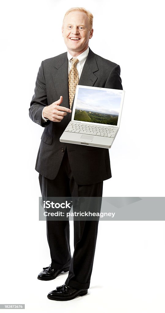 Smiling Businessman Points at Laptop (with clipping path) A smiling business man points to his laptop.  The laptop screen has a clipping path around it for easy drop ins.The image that appears on the screen is a photo I took of Chocolate Hills in the Philippines.  For just this image see Image File #: 11991039. Businessman Stock Photo