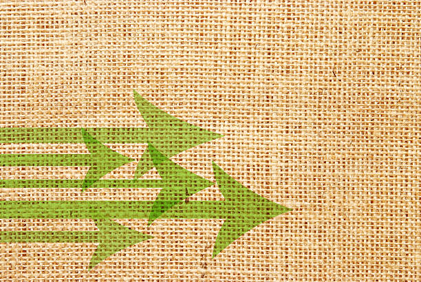 grüne pfeile auf hessian material - backgrounds burlap textured effect textile stock-grafiken, -clipart, -cartoons und -symbole
