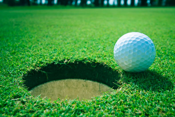 Golf ball near the hole stock photo