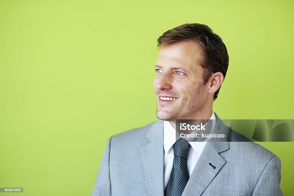 Sonriente hombre de negocios mirando lejos contra fondo verde - Foto de stock de Fondo verde libre de derechos