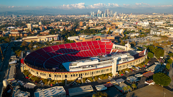 Los Angeles, CA - November 17, 2023: Los Angeles Memorial Coliseum, home to USC football, Olympics and other events, with Los Angeles skyline in the background