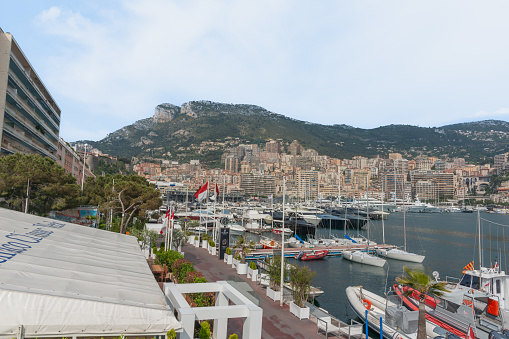 Fontvieille, Monaco - March 28 2019: Boats moored in the Port de Fontvieille with the hills behind.