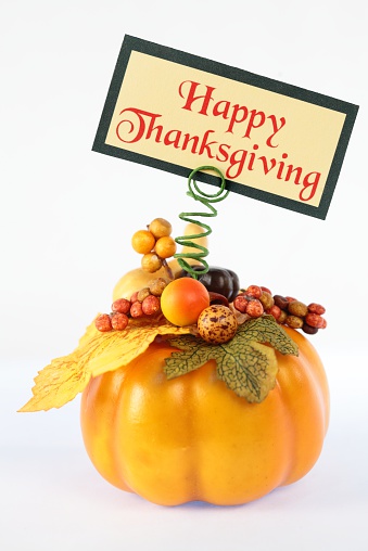 Decorated pumpkin with Happy Thanksgiving note card. Vertical image. 