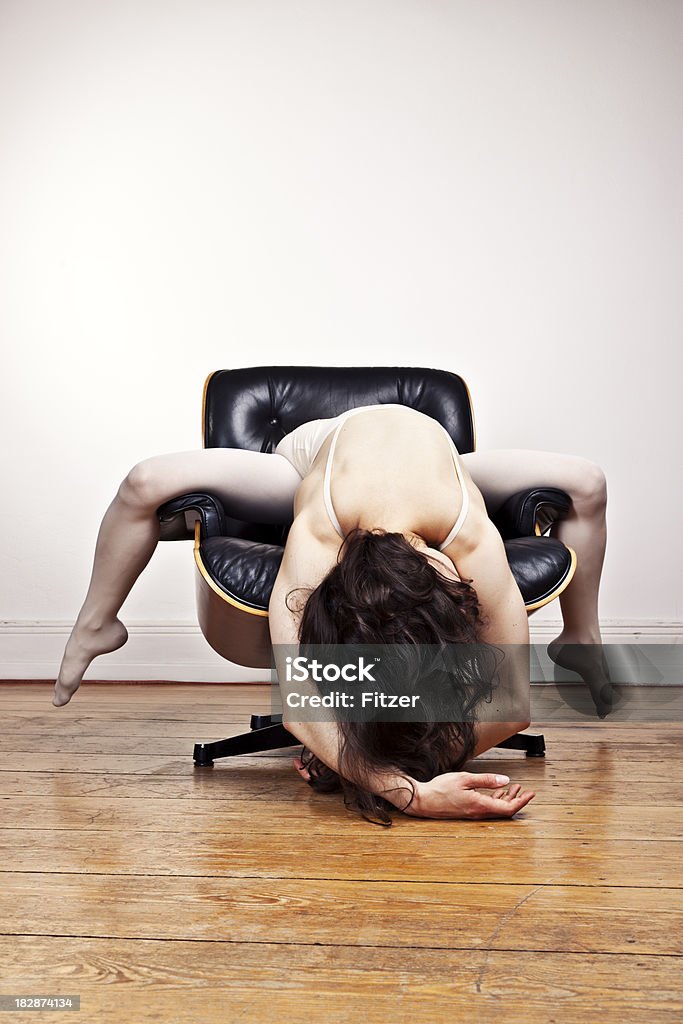 Jovem flexível Mulher s'exercitando em uma cadeira lounge, ambiente interno - Foto de stock de 20 Anos royalty-free