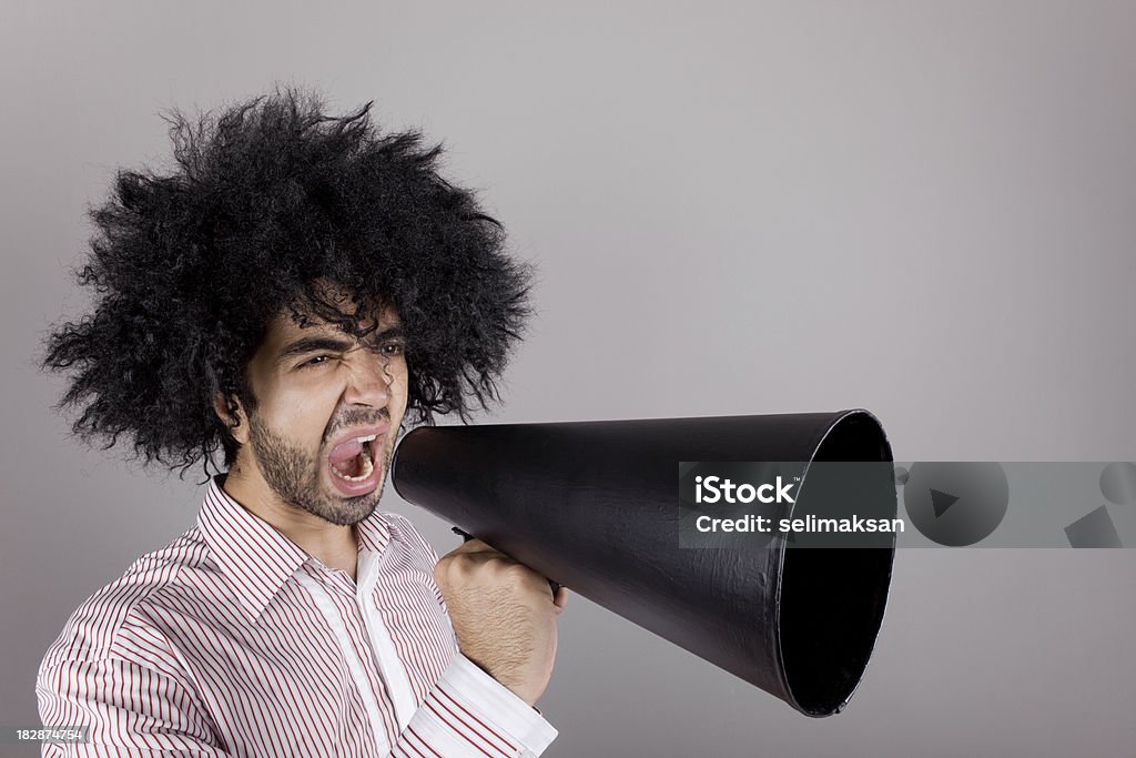 Bizzare man with curly hair shouting on old fashioned megaphone "Bizzare man with curly hair shouting on old fashioned megaphone, studio shot" Adult Stock Photo