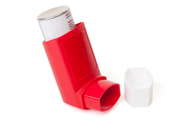 Red asthma inhaler with cap off A red asthma inhaler with cap removed isolated on a white background. asthma inhaler stock pictures, royalty-free photos & images