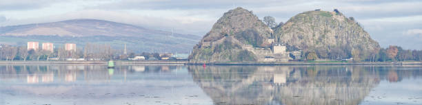 Dumbarton castle on volcanic rock overlooking the River Clyde with Ben Lomond in the background Dumbarton castle on volcanic rock overlooking the River Clyde with Ben Lomond in the background UK dumbarton castle stock pictures, royalty-free photos & images
