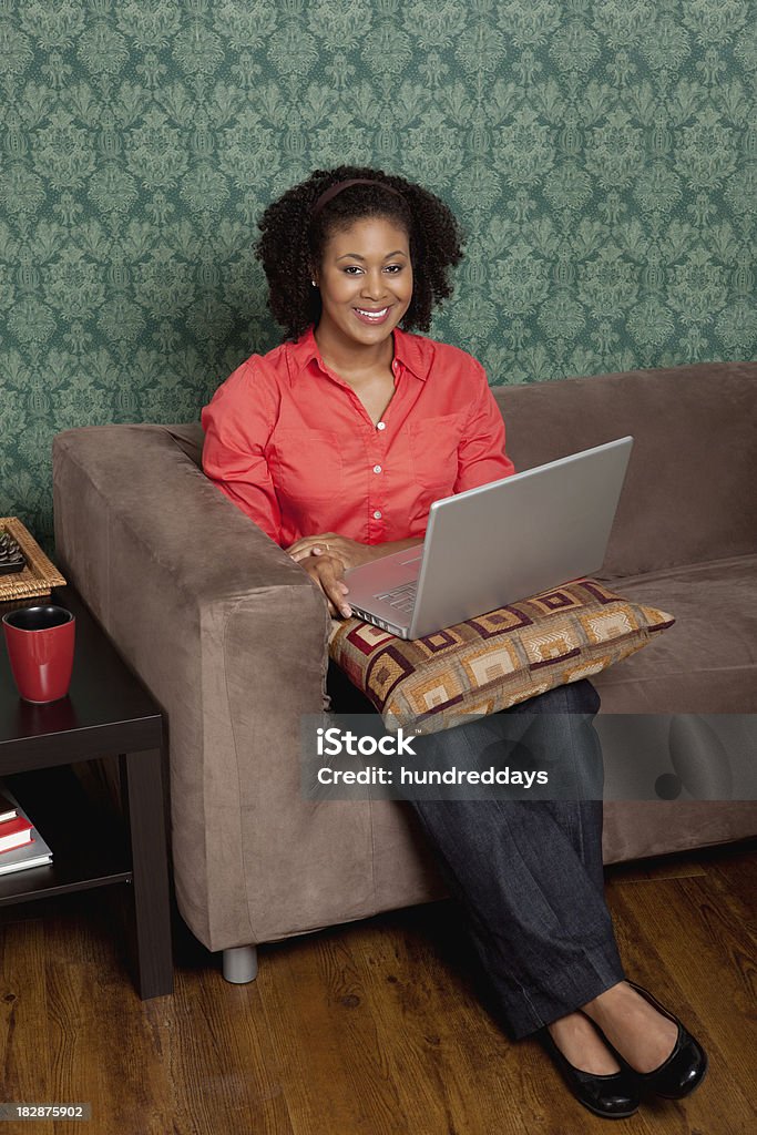 La lunghezza di una giovane donna utilizzando il computer portatile a casa - Foto stock royalty-free di 25-29 anni