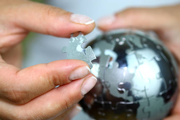 globus puzzle lösung - globe earth world map human hand stock-fotos und bilder