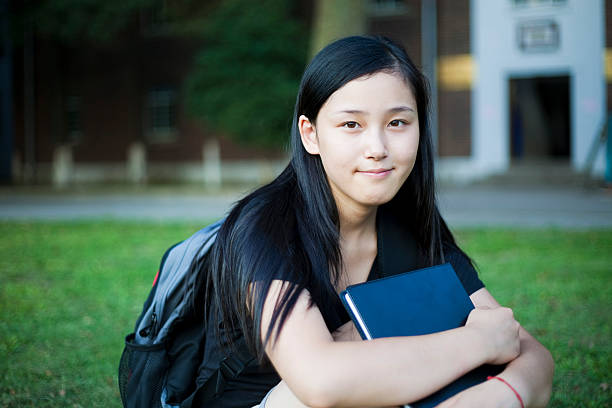 istock Schoolgirl sitting on grass 182876166