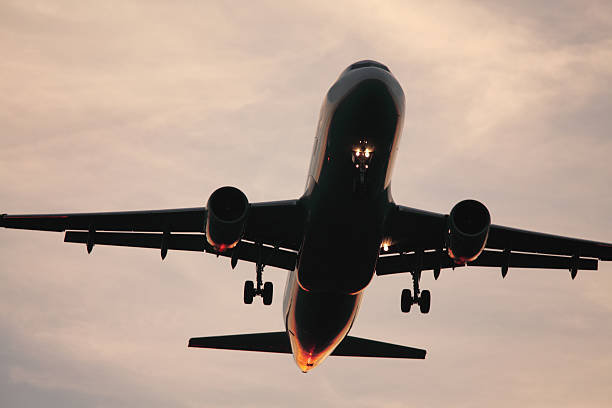 istock airplane landing or starting at sunrise 182876870