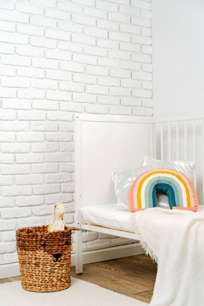 istock Kid's room interior with comfortable bed and rainbow pillow 1828770511