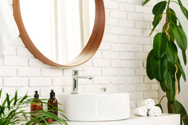 istock Bathroom interior with circle shaped mirror in wooden frame and white sink 1828770514