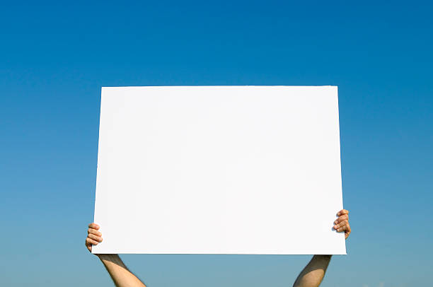 istock Hands Holding Blank Billboard against Blue Sky.Add Your Message 182877360