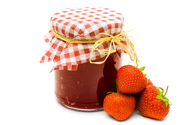Home made strawberry jam jar with fresh organic strawberries.-
