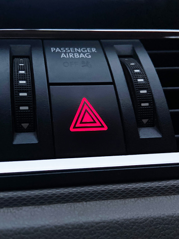 Car hazard lights button. Vehicle emergency lights push button on dashboard