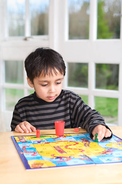 istock Little boy playing a board game with dice by himself 182878130