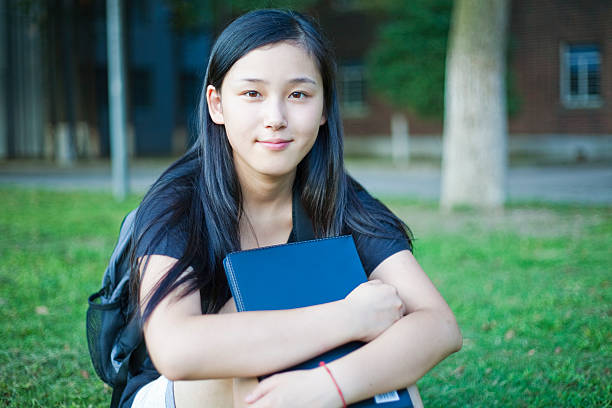 istock Schoolgirl sitting on grass 182878415
