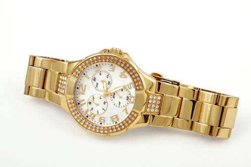 Close-up of a women's crystal accented gold-tone watch. Isolated on white.