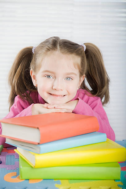 istock Little Girl Looking at Camera with Books 182880736