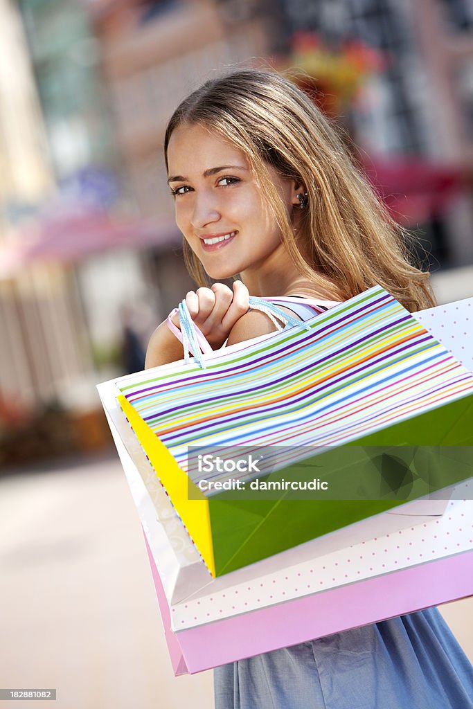 Donna giovane che trasportano borse per gli acquisti - Foto stock royalty-free di Abbigliamento casual